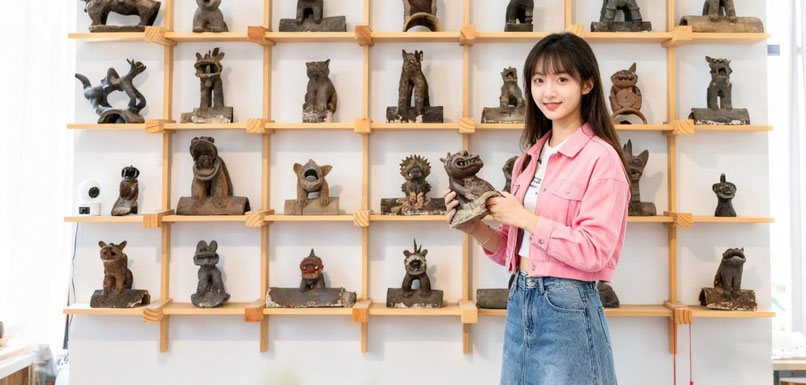 一名顾客在挑选云南瓦猫工艺品