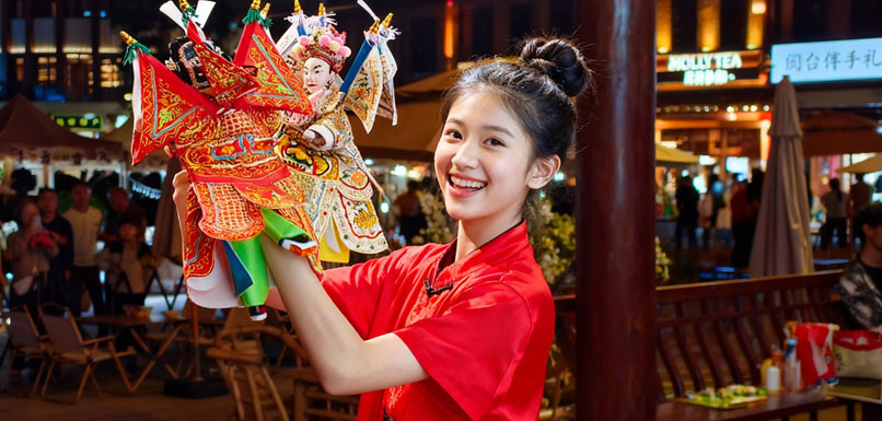 漳州古城内，一位年轻艺人在表演布袋木偶戏